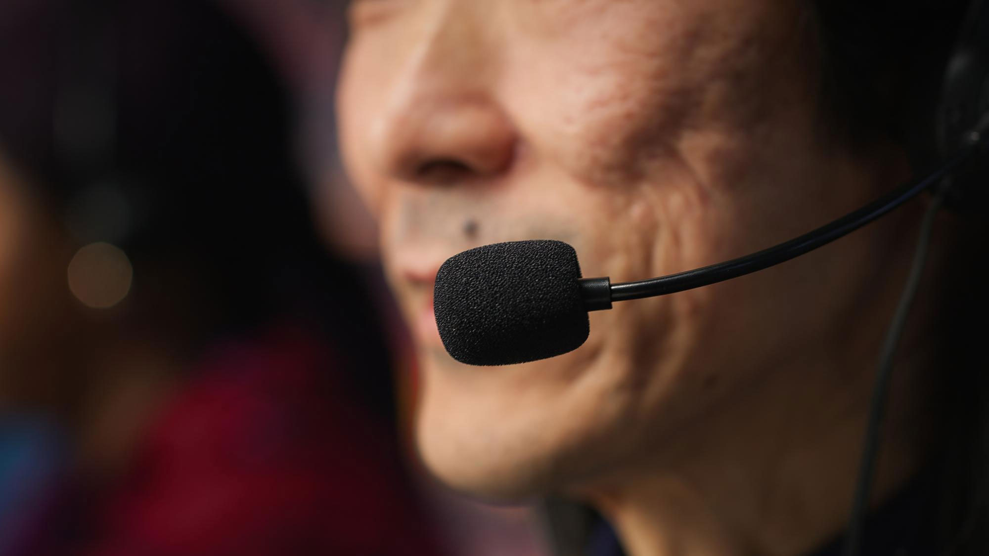 Close-up of an on-site interpreter speaking into a headset microphone